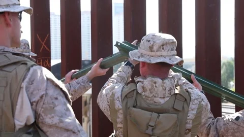 U.S. Marines positioning metal posts to attach to the Mexican border fence Stock Footage 300261076