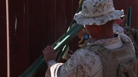 U.S. Marines positioning metal posts at the Mexican border fence Stock Footage 300261101