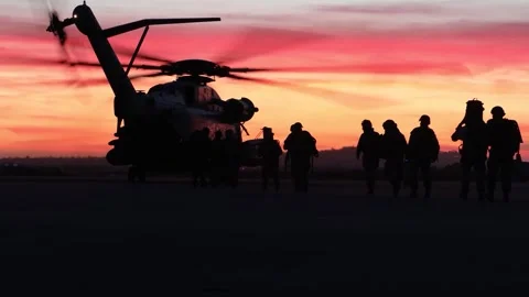 U.S. Marines walking towards CH-53 Super Stallion at sunset Stock Footage 257891108