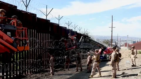 U.S. Marines at work securing razor wire to the southern border wall Stock Footage 301195142