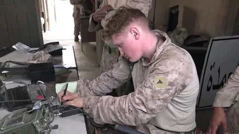 U.S. Marines writing in notebook while listening on satellite radio Stock Footage 257417912
