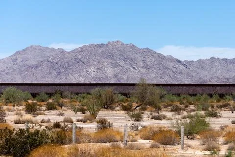 US-Mexico border wall crossing the Sonoran Desert landscape. Fotos de archivo