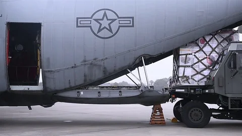 US military members push a cargo load onto a huge plane 스톡 동영상 83320522