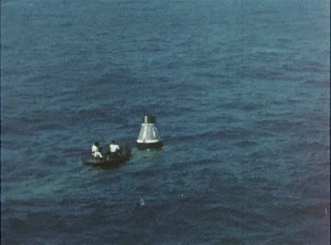 U.S. Navy crew approaching space capsule in dinghy after touching down in sea Stock Footage 262444934