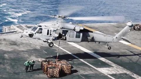 U.S. Navy deck crew attach hoist to MH-60 Seahawk during replenishment at sea Stock Footage 161794579