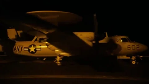 U.S. Navy E-2 Hawkeye aircraft launches from USS Dwight D Eisenhower at night Stock Footage 261811837