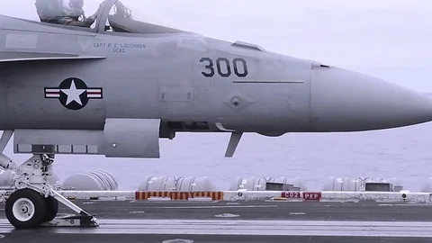 US Navy F-18 hornet fighter jet take off from Nimitz class aircraft carrier Stock Footage
