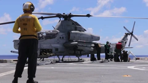 U.S. Navy flight deck personnel aboard USS Green Bay receive AH-1Z Viper  Video stock 283073377