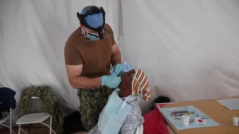 U.S. Navy medic performs dental work on resident at medical site  Видео 227138283