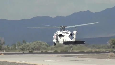 U.S. Navy MH-60 Seahawk with white paintwork taking off from NAS Fallon, Nevada Stock Footage 275824183