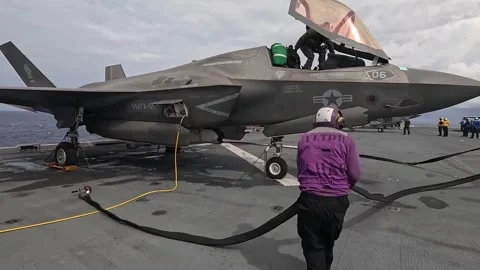 U.S. Navy sailor adjusting fuel hose for U.S. Marines F-35B aboard USS America Stock Footage 283346392