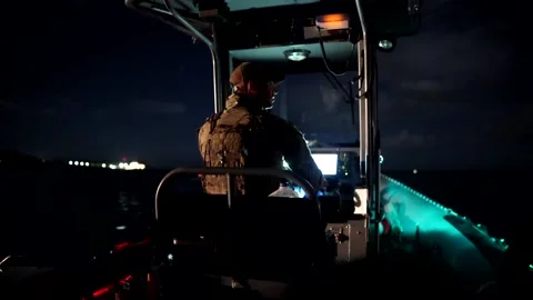 U.S. Navy sailor navigating boat at night Stock Footage 201074898