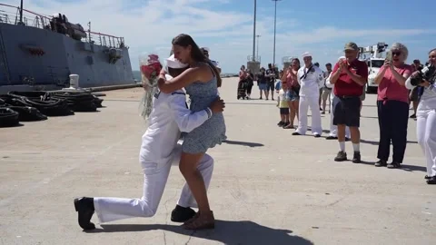 U.S. Navy sailor proposing on one knee with ring on arriving from deployment Stock Footage 209492247