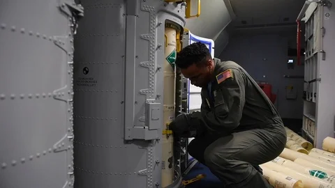 U.S. Navy sailor securing sonobuoy into position in launcher oboard P-8 Poseidon Stock Footage 110732253