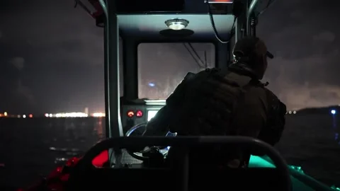 U.S. Navy sailor steering boat at night Stock Footage 201074834