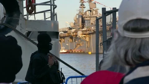 US Navy security by harbor fence, warship in background, Stockholm Stock Footage 320744342