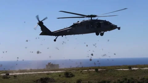 U.S. Navy SH-60 Seahawk helicopter kicking up vegetation on approach Stock Footage 267958289