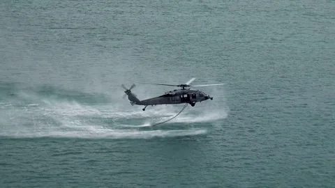 U.S. Navy SH-60 Seahawk dropping ladder into water for helocasting Stock Footage 279729181