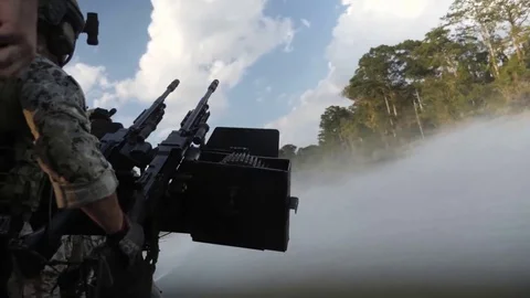 US Navy Special Warfare. Machine gunner from the back on a boat Stock Footage 121890189
