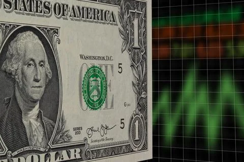 US one dollar standing in perspective with blurred stock market index Stock Photos