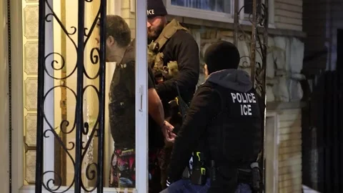 U.S. Police ICE agents escorting hand-cuffed immigrant from property Stock Footage 300167151