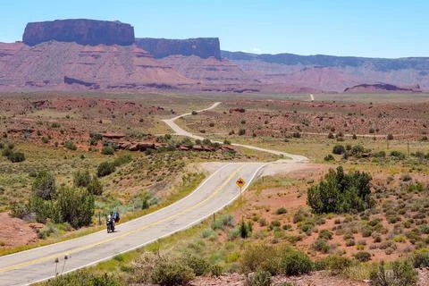 US road 128 winding through Utah desert between red cliffs on abeautiful day of Stock Photos