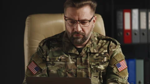 U.S. serviceman planning mission strategy while working on laptop in office Stock Footage 334668194