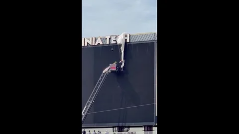 US: Skydiver rescued after getting stuck on stadium scoreboard in Blacksb... Stock Footage 333125000