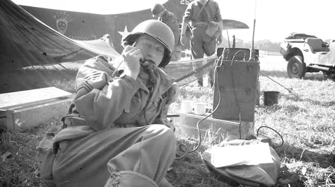 US Soldier making radiocall with in background glider Stock Footage 41810292