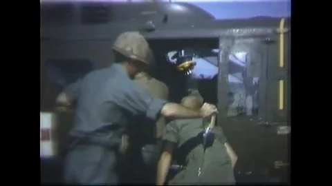 U.S. soldiers load wounded native into UH-1D copter - 1966 Video stock 91261708