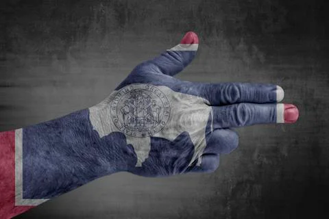 US state flag of Wyoming painted on male hand like a gun Stock Photos