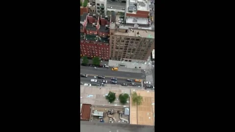 US: Strong wind blows away debris from high-rise apartment building in NYC Vídeos de archivo 170450525