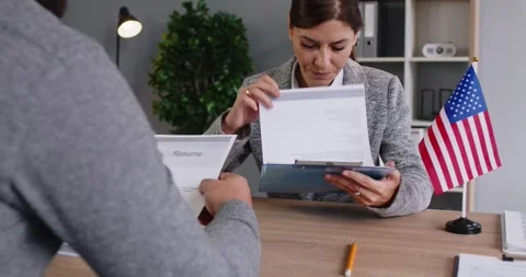 US visa and citizenship interview with officer reviewing applicant documents Stock Footage 323247539