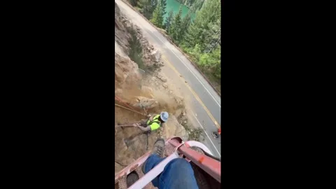 US: Worker Uses His Back To Push Huge Cliff As Rocks Crash Down Above Was... Stock Footage 334759742