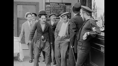 USA - 1914 - In this silent comedy, a drunk artist (Charlie Chaplin) uses chalk Stock Footage 340574213
