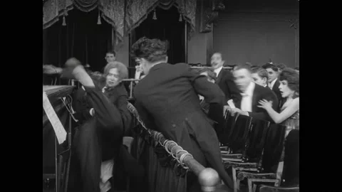 USA - 1915 - In this silent comedy, a man (Charlie Chaplin) starts a fight with Stock Footage 316409338