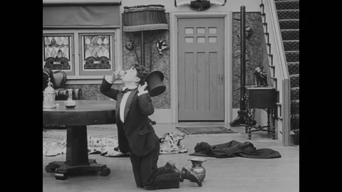 USA - 1916 - In this silent comedy, a drunk man (Charlie Chaplin) throws his hat Video stock 323262818