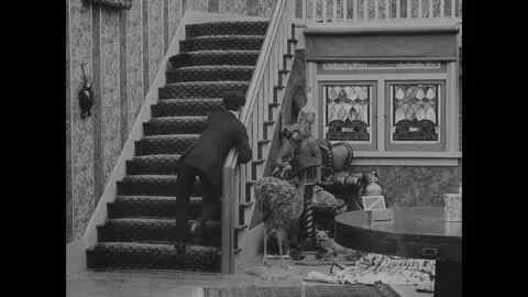 USA - 1916 - In this silent comedy, a drunk man (Charlie Chaplin) finally gets Stock Footage 323263520