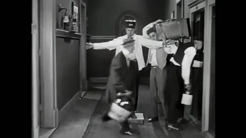 USA - 1920 - In this silent comedy, a man runs out of a hotel room handcuffed to Stock Footage 327754532