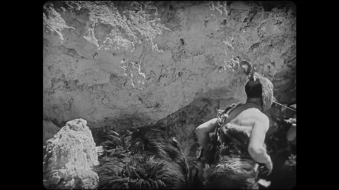 USA - 1928 - In this silent comedy, a caveman (Oliver Hardy) throws another off Stock Footage 340577565