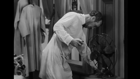 USA - 1930 - In this comedy, a dentist adjusts his patient's skirt when the fan Stock Footage 323259612