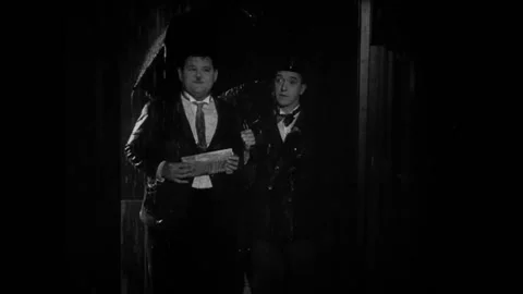 USA - 1930 - In this comedy, two men in bowler hats stand in the rain in a Vídeos de archivo 325205831