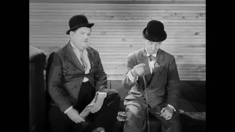 USA - 1930 - In this comedy, two men in bowler hats sit on a dock catching fish Stock Footage 325206504