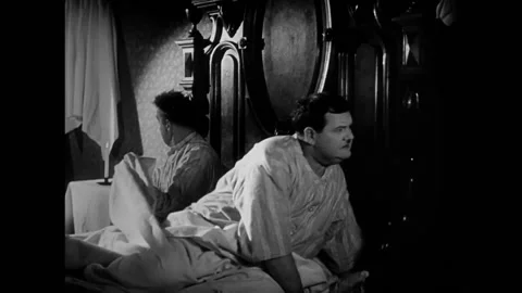 USA - 1930 - In this comedy, two men sit in a bed, a candle is dropped down one Stockbeeldmateriaal 325217040