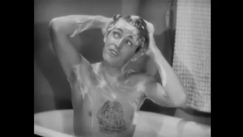 USA - 1930 - In this romantic comedy, a man takes a bath and another man shaves Stock Footage 341988810
