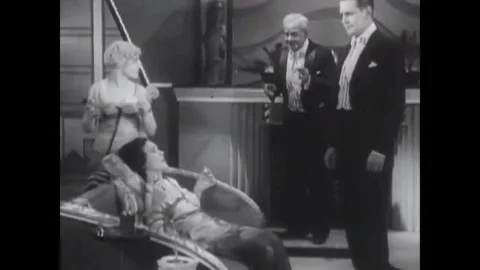 USA - 1930 - In this sci fi musical, people speak to a woman laying on a couch. Vidéo 341982715