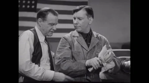 USA - 1930s - Two men speak in front of an American flag about honing medals. Stock Footage 327737833