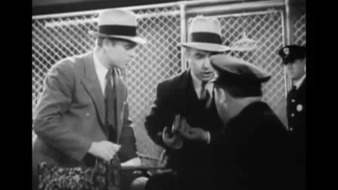 USA - 1931 - In this comedy, two men in suits show officers a stack of cash. Stock Footage 341982110