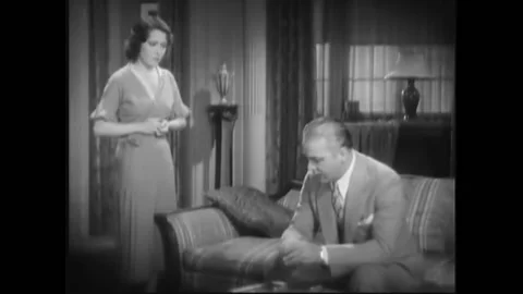 USA - 1932 - In this pre-code drama, a man and woman speak in the living room Stock Footage 327735737