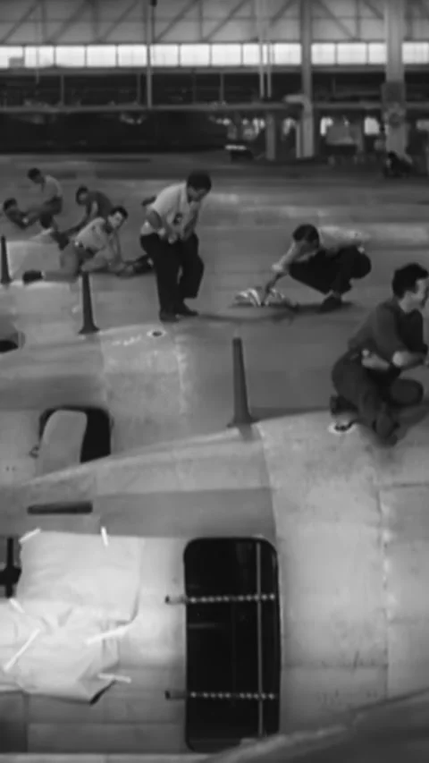 USA - 1940s - Men work atop C-46 airplanes in a factory. Stock Footage 339107783